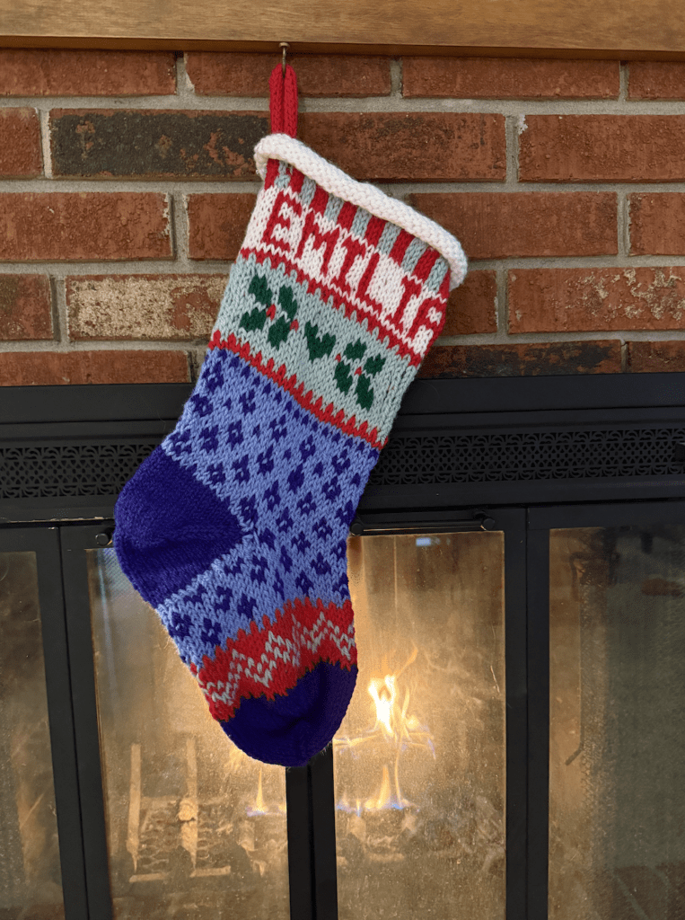 handknit christmas stocking hung by fire