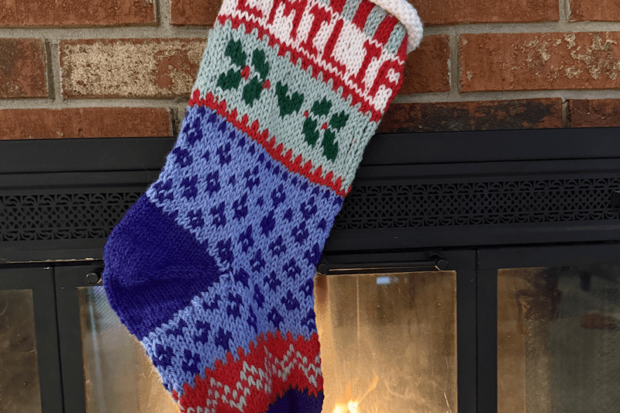 handknit christmas stocking hung by fire